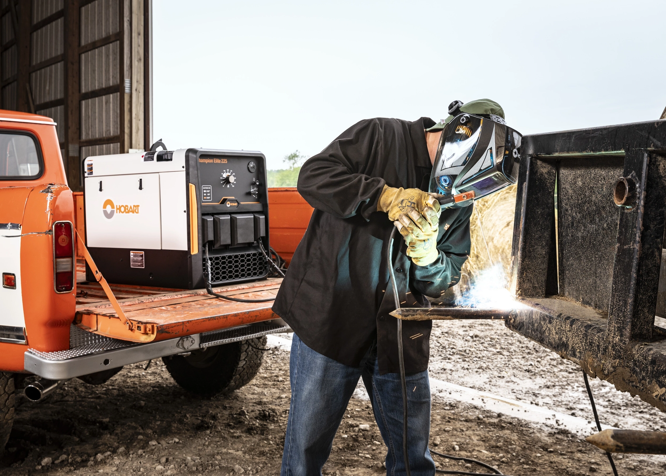 Welder welding front of skid steer using a Hobart Champion 225 Engine Driven welding machine